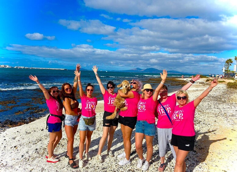 A group of people on a beach with the ocean and mountains in the background. 1