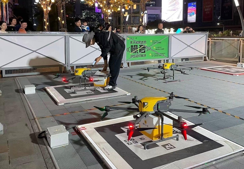 A person operating drones on a rooftop with a cityscape in the background. 2