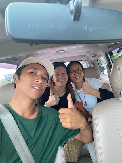 Three people in a car giving thumbs up. 3