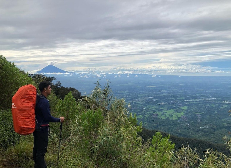 A hiker with a red backpack on a mountain trail. 4
