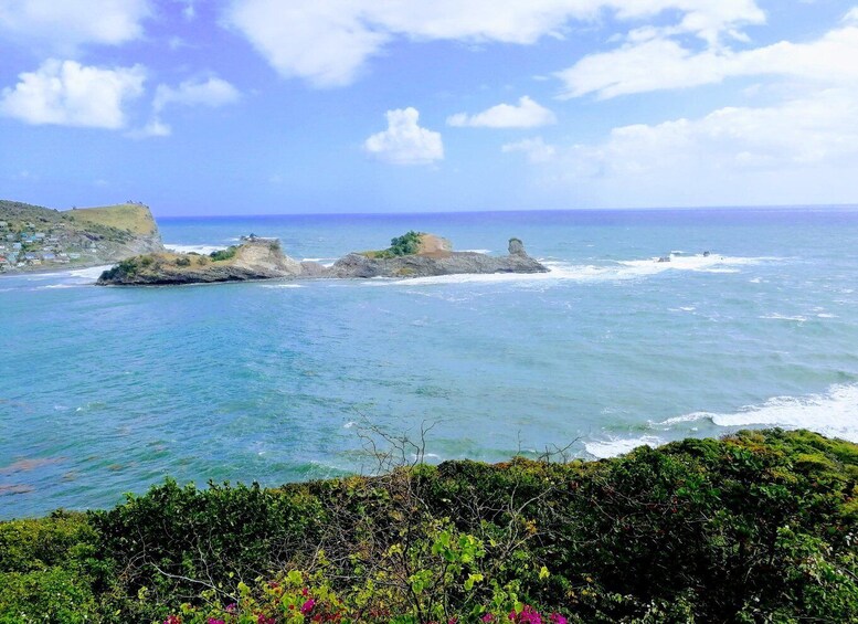 A coastal landscape with rocky outcrops and clear blue waters. 3