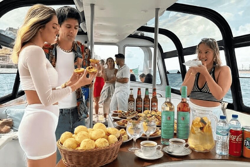A boat with people enjoying food and drinks, including a basket of bread, bottles of alcohol, and cups of coffee. 3