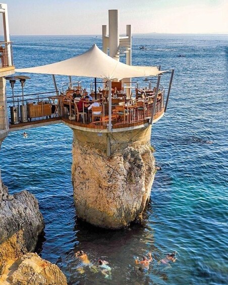 A restaurant on a rocky outcrop extending into the sea. 4