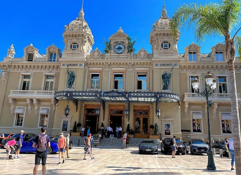 A grand building with ornate architecture, including statues and a clock. 1