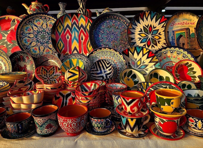 A collection of colorful ceramic plates, bowls, and cups with intricate patterns. 4