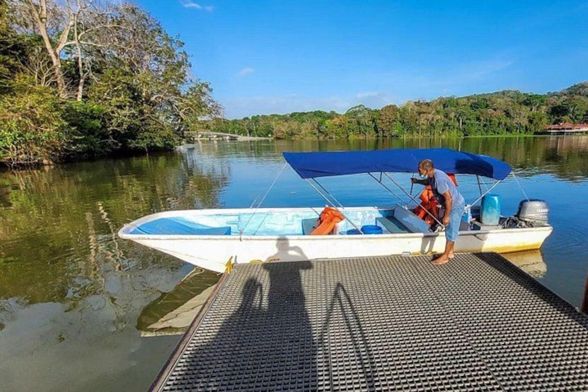 Ein Boot liegt an einem Steg, eine Person steht auf dem Deck. 2