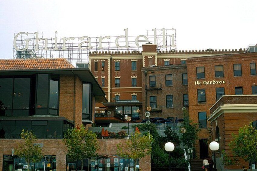 A building with a large sign reading 'Ghirardelli' and another sign for 'The Mandarin.' 2