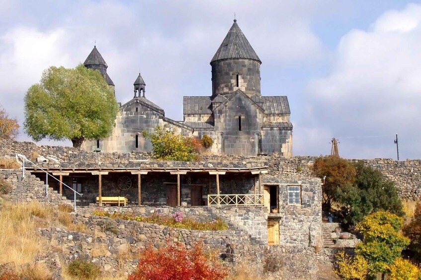 A historic stone building with multiple towers and a covered porch. 4