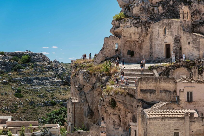 A historic stone building perched on a cliff with a staircase leading up to it. 4