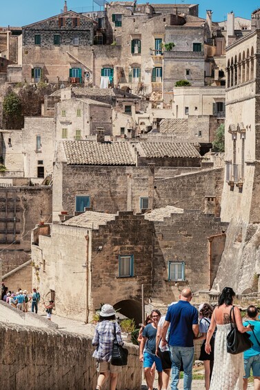 A historic stone town with tourists walking along a narrow street. 3