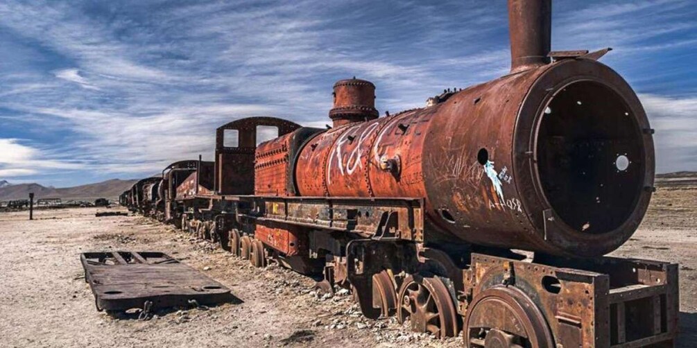 A rusted train engine in a desert landscape. 3