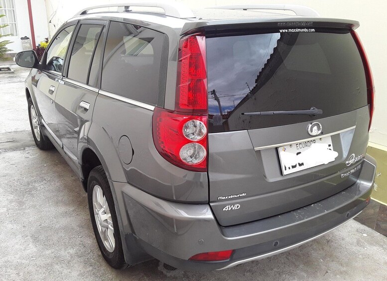 A gray SUV with a rear license plate from Ecuador, parked in a garage. 3