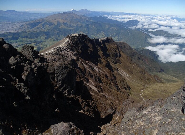 A rugged mountain peak with a clear sky and distant clouds. 2