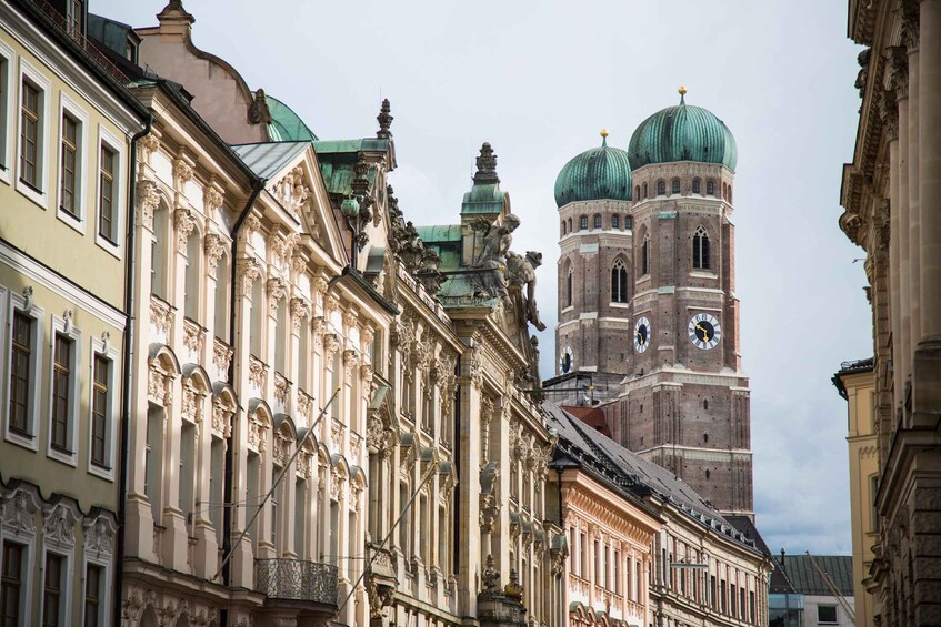 A historic building with ornate facades and a clock tower with green domes. 5