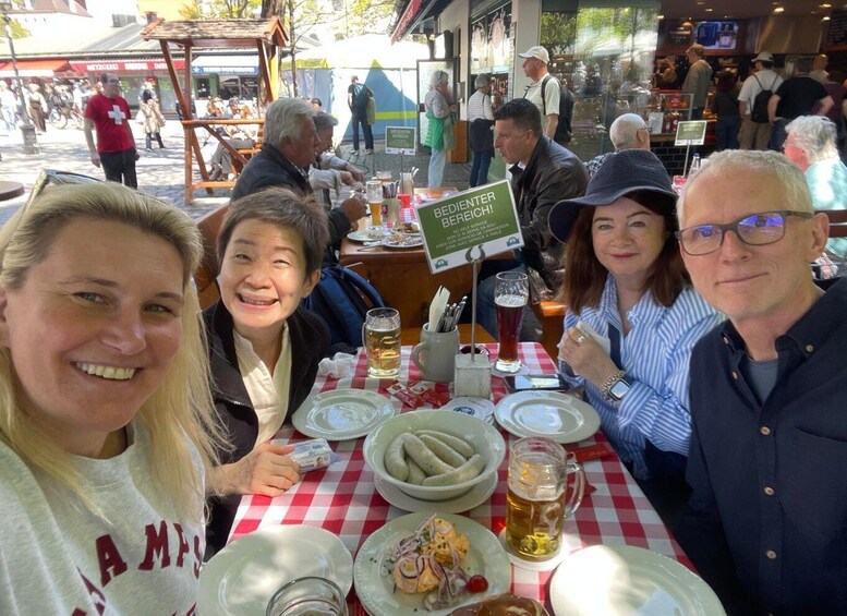 A group of people sitting at a table with food and drinks. 3