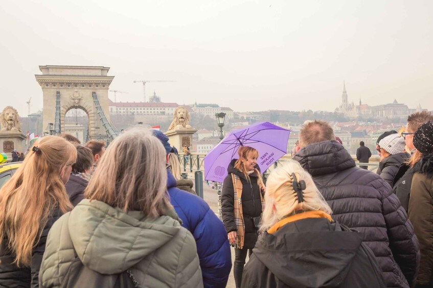 A group of people standing near a historic archway with a statue of a lion. 5