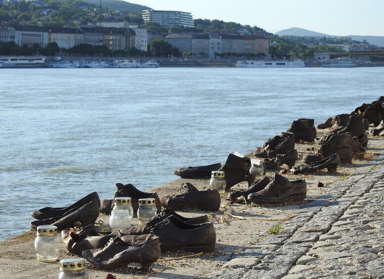 A riverbank with rows of old shoes and glass jars. 1