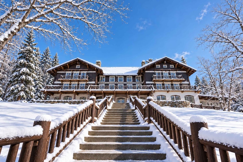 A large wooden building with a staircase leading up to a balcony. 2