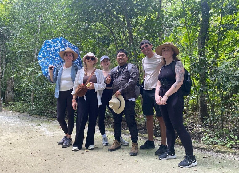 A group of people standing on a dirt path in a forested area. 5
