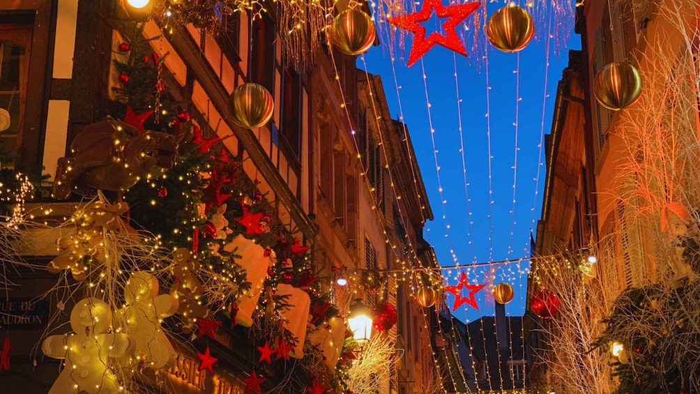 A decorated street at night with Christmas lights, ornaments, and a star. 5