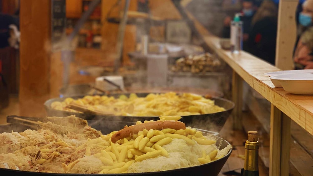 A food stall with various dishes including pulled pork, French fries, and a hot dog. 2