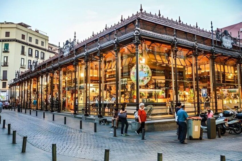 A historic building with ornate architecture, a cobblestone street, and pedestrians. 5