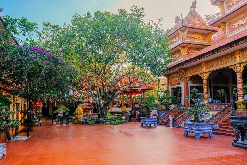 Une cour traditionnelle, agrémentée d’une architecture riche et travaillée, d’un grand arbre et de plantes en pot. 5