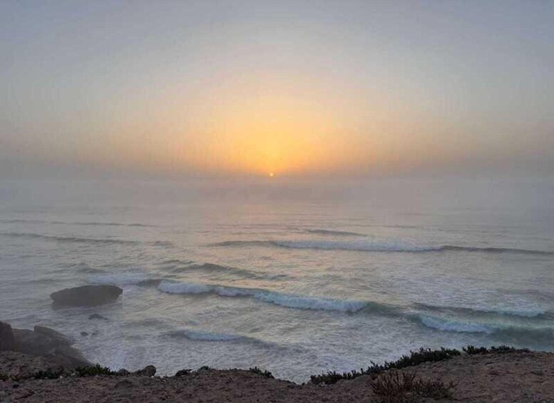 A beach with waves and a sunset. 2