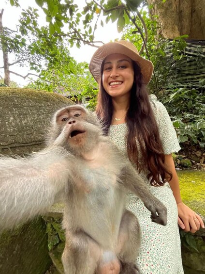 A person in a white dress with a hat, standing next to a monkey. 4