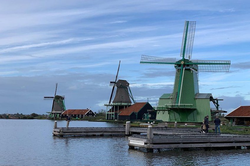 Windmills, a wooden dock, and a calm body of water. 2