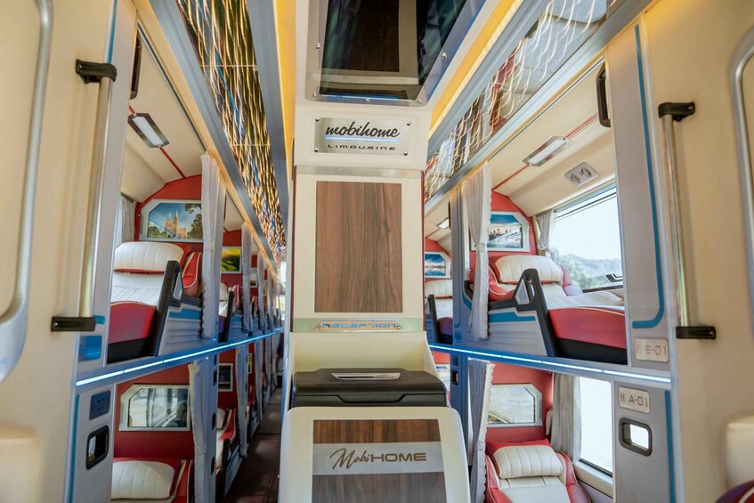 A train interior with red and white seats, a central aisle, and a 'Mobihome' sign. 2