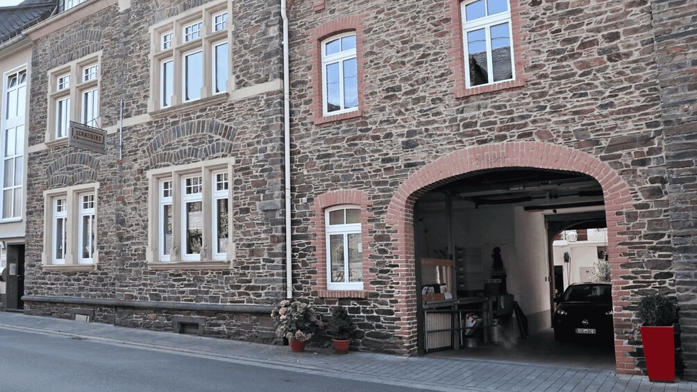 A stone building with multiple windows and a garage entrance. 3