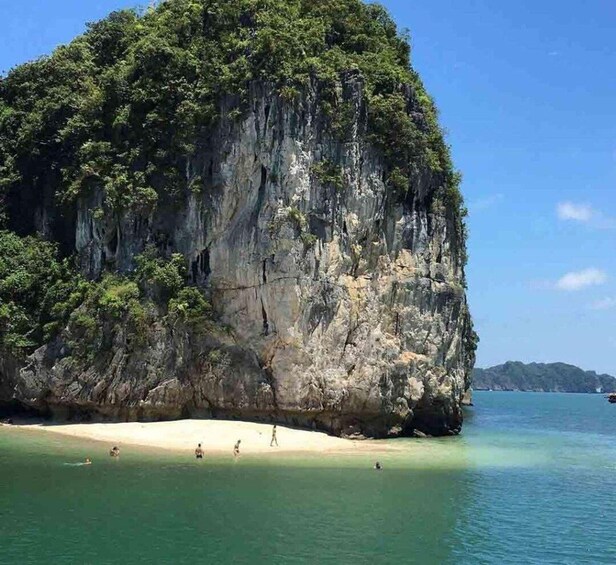 A large limestone cliff with a beach at its base. 4