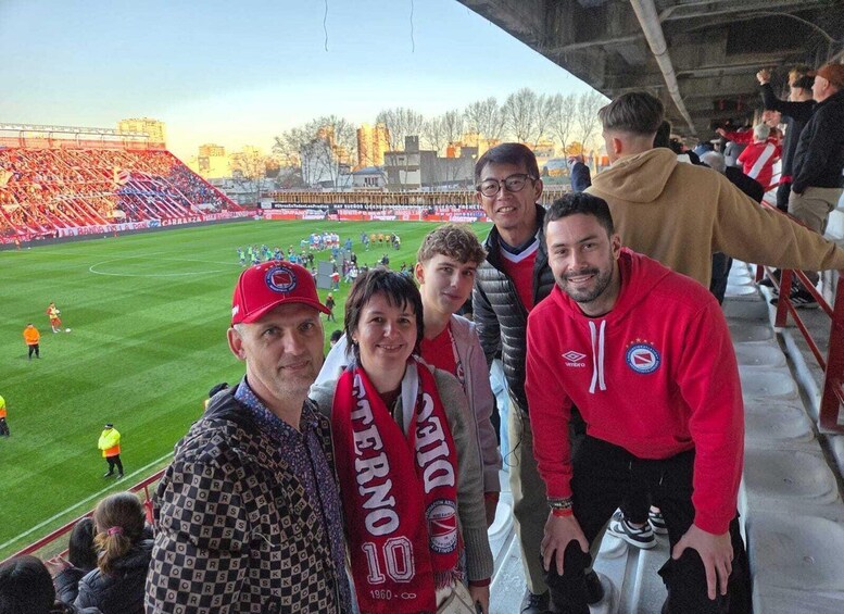 A group of people at a sports stadium with a football field. 4