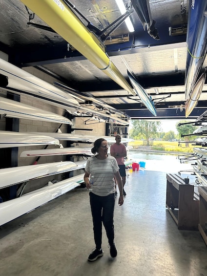 A person walking in a boat storage area with boats and equipment. 4