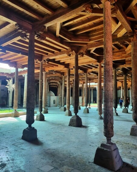 An ancient architectural structure with wooden beams and stone columns. 1