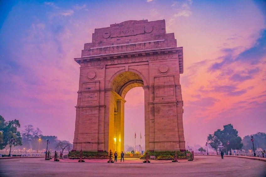 India Gate -monumentti auringonlaskun aikaan, taivaalla vaaleanpunainen sävy. 5
