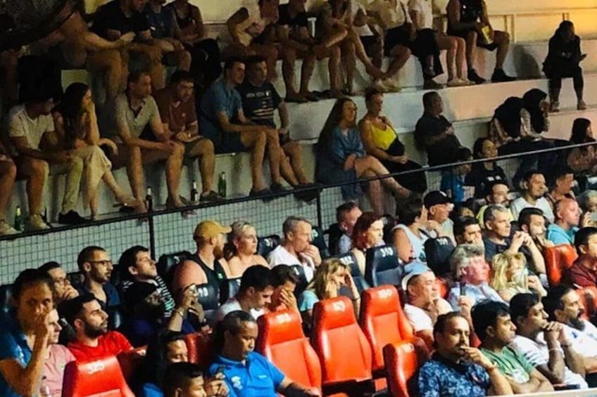 A crowded stadium with spectators seated in rows. 2