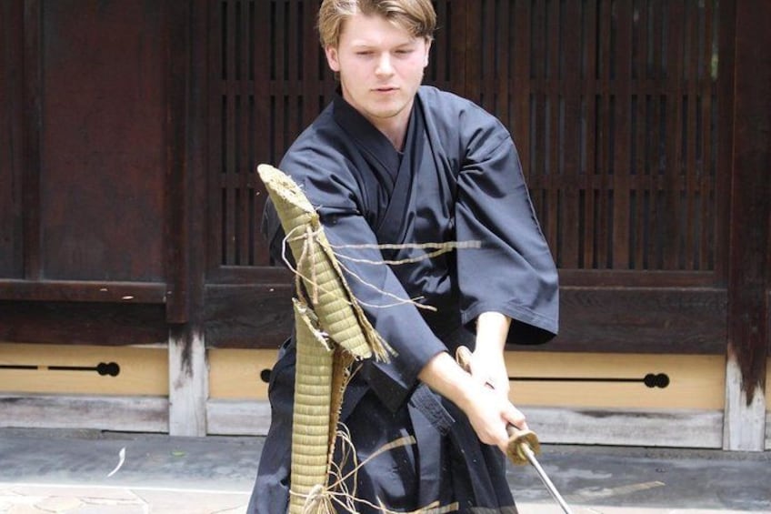 A person in traditional attire holding a long, flexible object. 1