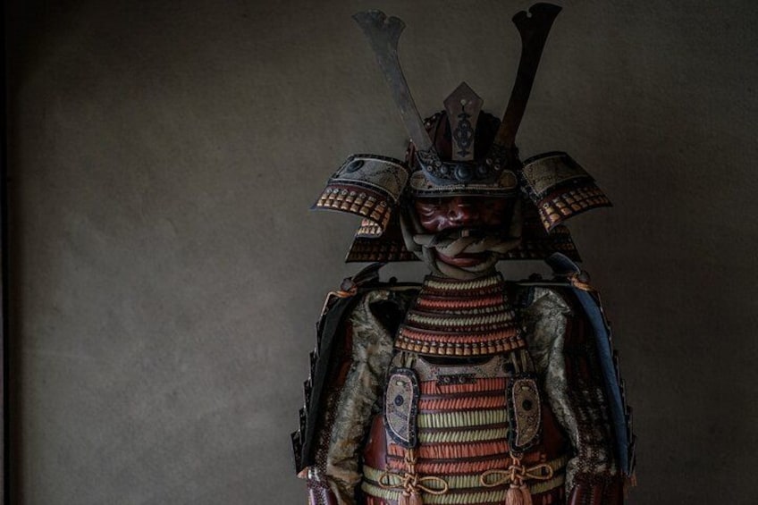 A samurai in traditional armor with a helmet and two swords. 4