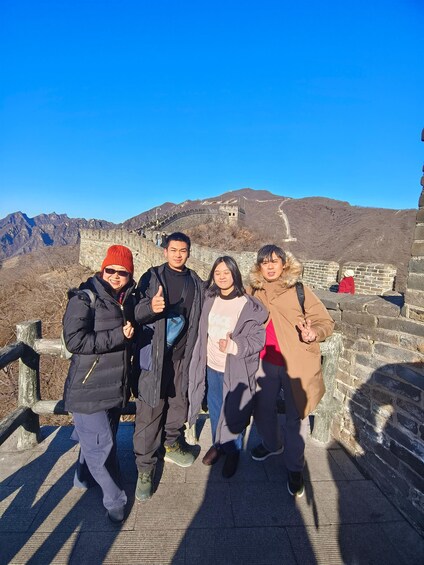 A group of people standing on the Great Wall of China with a mountainous backdrop. 4