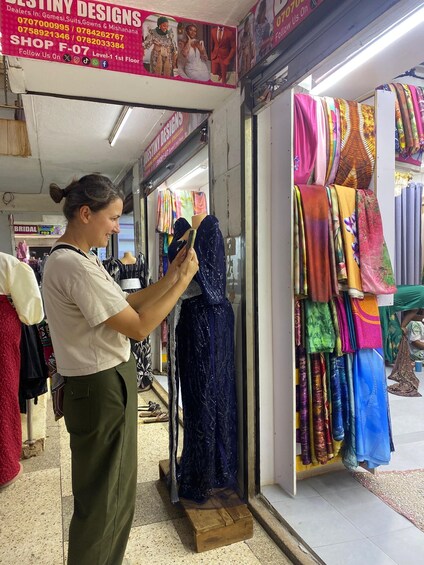 A woman examining a blue dress in a shop. 2