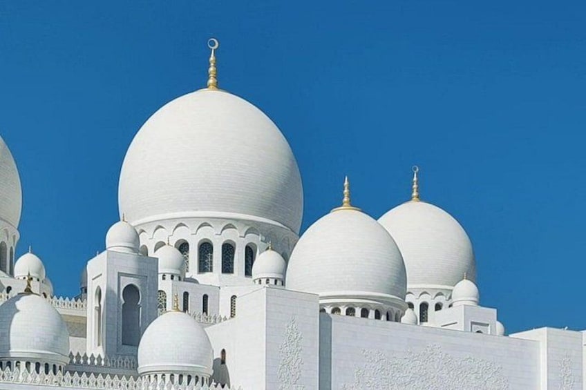 Un edificio bianco con numerose cupole e un cielo azzurro intenso. 3
