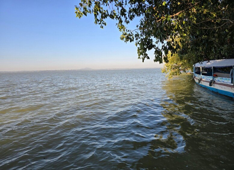 A boat on a calm river with a clear sky and distant mountains. 4