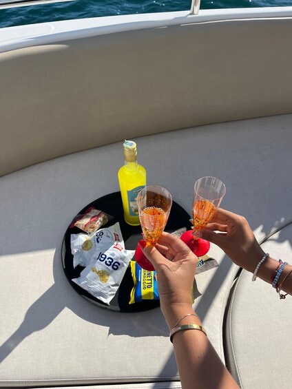 Two people toasting with drinks on a boat. 2