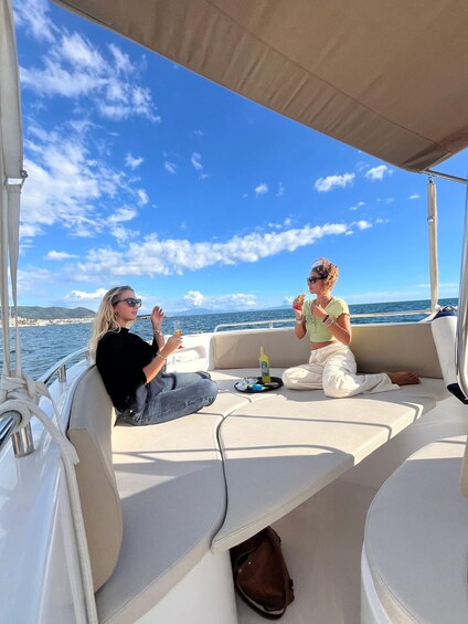 Two people on a boat, one holding a drink and the other with a bottle. 5