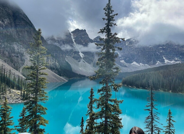 A turquoise lake surrounded by mountains and coniferous trees. 1