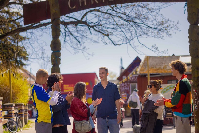 A group of people standing outdoors, engaged in conversation. 2