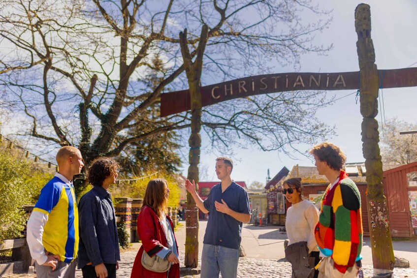 A group of people standing in front of a sign that reads "CHRISTIANIA". 1