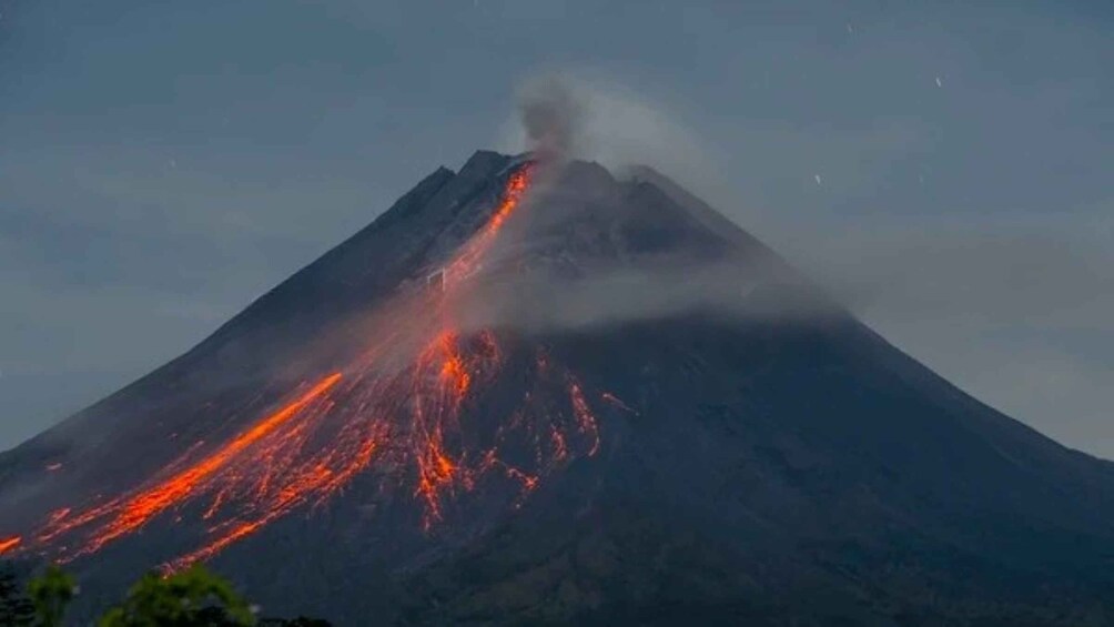 A volcano with lava flowing down its side. 3